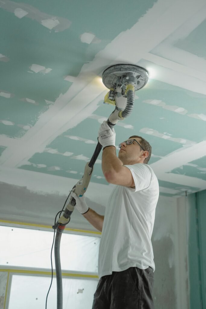 A Man in White Shirt Painting a House